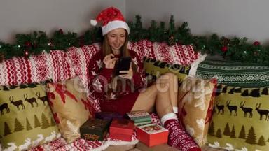 圣诞老人帽中的幸福女人使用智能<strong>手机</strong>，圣诞<strong>节</strong>概念，新年假期