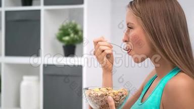 快乐美丽的早晨，女人在厨房的特写镜头中用勺子从碗里<strong>吃月饼</strong>麦片