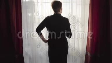 傍晚站在大窗户边，一位棕色短发的白种人优雅女士喝着葡萄酒后景