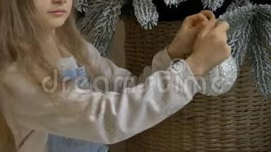 小女孩正在用大银宝装饰圣诞树。 可爱的金发女孩准备回家过圣诞节