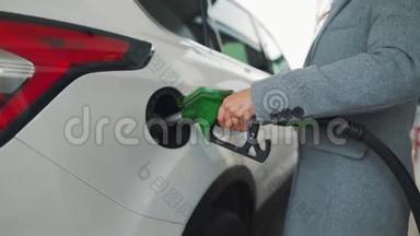 一个女人在加油站的车里加油