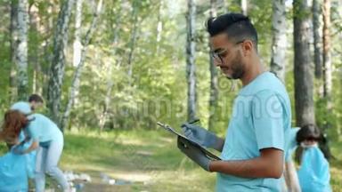 阿拉伯男子在夏季公园清理期间做文书工作的肖像