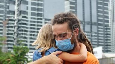 一个抱着一个女儿的男人，一家人为自己抵御2019年的冠状病毒