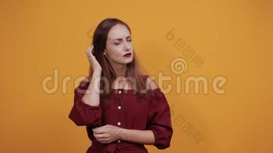 穿栗色连衣裙的<strong>不开心</strong>的女人纠正发型，把手放在肚子上