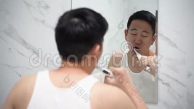 亚洲男人用<strong>电动牙刷</strong>清洁牙齿
