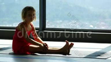 女孩做体操，在体育馆的垫子上做伸展运动