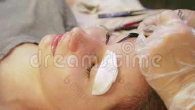 美容师从顾客的眉毛上清洗指甲花，并涂上一种特殊的奶油。