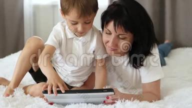 妈妈和<strong>小</strong>男孩玩<strong>游戏</strong>或在平板电脑上为孩子们使用应用<strong>程序</strong>。