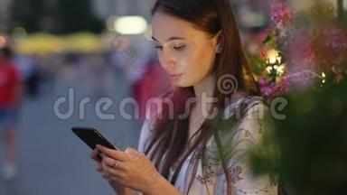 女孩在等约会。 她一个人在夜城打手机