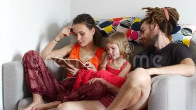 <strong>一家人</strong>在一起，一个女人给丈夫和<strong>女儿</strong>读一本书
