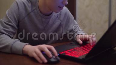 玩家在游戏笔记本上玩电子游戏，团队射击，红色霓虹灯键盘