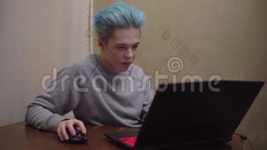玩家在笔记本电脑上玩在线电子游戏，专注于游戏，蓝色头发