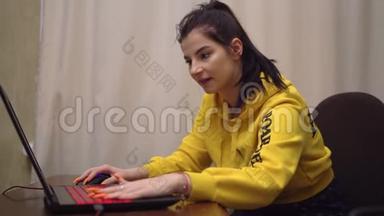 年轻玩家女孩在笔记本电脑上玩在线电子游戏，情感游戏，胜利者