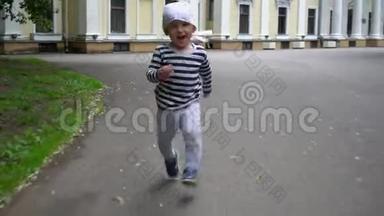 活跃的幼儿男孩在公园的沥青路上跑步。 关节活动度射击