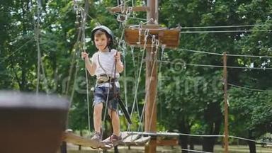 一个小男孩在一个<strong>绳索</strong>公园里经过一个景点。