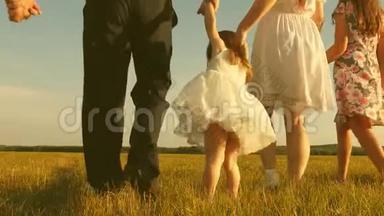 幸福的一家人带着孩子，正沿着田野向远处的蓝天走去。 妈妈，爸爸，女儿