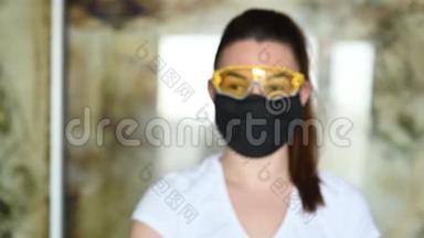 戴防护面罩、眼镜和手套的女孩喷洒防腐剂以防止感染。