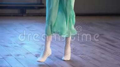 在芭蕾训练期间，一个穿白色芭蕾舞鞋的女孩`在一个旧木地板上的腿特写。 古典元素