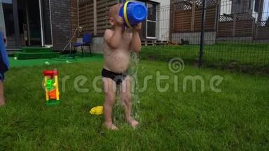 小男孩儿子从玩具桶里倒水。 可爱的小孩玩得开心