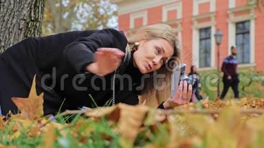 一位年轻的白人女摄影师在老式<strong>复古</strong>胶卷相机上<strong>拍摄</strong>秋季照片。潮人拍得低