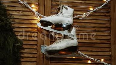用于花样滑冰的旧<strong>溜冰</strong>鞋和磨损的<strong>溜冰</strong>鞋挂在有照明的墙上。冬季运动与爱好