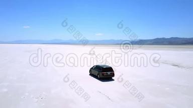 无人机跟随汽车向前行驶，沿着犹他州邦纳维尔的平坦盐湖沙漠令人难以置信的大气景观。