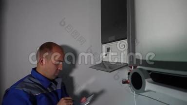 有平板电脑的工人在家中安装中央燃气供暖锅炉