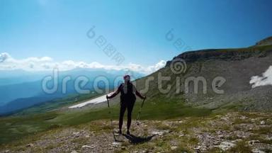 女人在美丽的高加索山脉徒步旅行。 在去山顶的路上，带着背包和徒步旅行杆的年轻女子