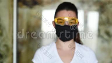 戴防护面罩、眼镜和手套的女孩喷洒防腐剂以防止感染。