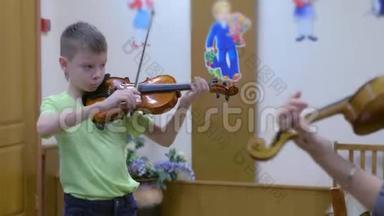 小男孩学生在<strong>音乐学校</strong>的<strong>音乐</strong>课上和老师一起拉小提琴。