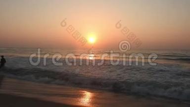 日落日出时，太阳正落在地平线上，越过海洋或海洋。 宁静的海洋海浪。 天然天空蓝色和橙色。