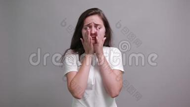 不高兴的女人穿着白色衬衫哭着，擦去眼泪，把手放在腰带上