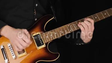 吉他手演奏<strong>一把</strong>浅棕色的六弦电吉他，在黑色背景下挑<strong>一把</strong>。 呆在家里的概念