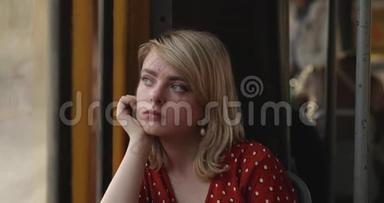 年轻体贴的女人坐在电车里，<strong>望</strong>着<strong>窗外</strong>的肖像。 带着一个