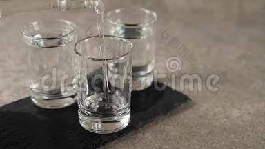 用手将伏特加、龙舌兰酒或清酒从平装瓶中倒入一杯，从三个玻璃杯中倒入大理石
