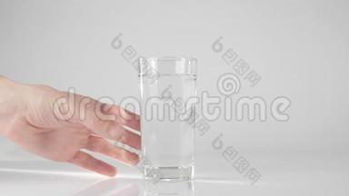 手拿一杯纯淡水从白色的桌子在白色的<strong>背景</strong>下。 呆在家里吃<strong>健康食品</strong>的观念