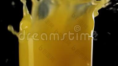 用新鲜橙汁将冰块倒入高杯中，在黑色背景下溅出气泡