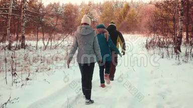 冬天，三个游客在乡间小路上散步，穿着暖和的衣服