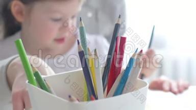 幸福的家庭，妈妈保姆教可爱的小女孩在桌子旁画画，妈妈帮小女儿学画画