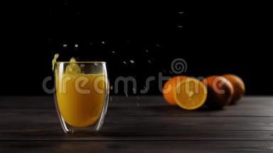 在一个装有新鲜橙汁的双壁玻璃杯中，冰块在木桌上溅出大量的气泡