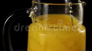调酒师用勺子在黑色背景下，用一个缓慢运动的<strong>解码器</strong>搅拌新鲜橙汁冰块。