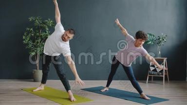 男教练在舒适的工作室教女<strong>瑜伽学生</strong>，人们正在做体式