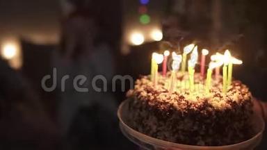 幸福的微笑卷曲的红头发女孩吹蜡烛在她的小生日蛋糕。 她身边最亲密的女孩