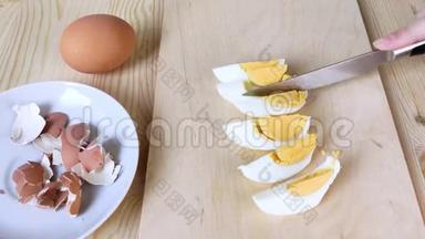 煮鸡蛋用刀切.. 蛋白质食物。 早餐或健康小吃.. 特写，木制桌子