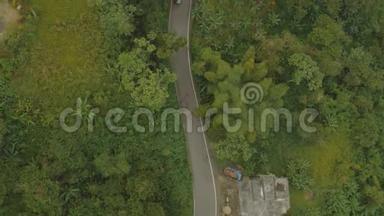 空中建立汽车在山区雨林道路上行驶的镜头。