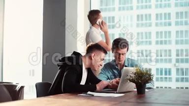 两个年轻的创业者们一起用笔记本电脑在餐桌上讨论项目