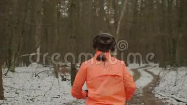 戴着<strong>耳机</strong>的女人在公园里完成了锻炼。 后侧跟随<strong>运动</strong>女<strong>运动</strong>员在冬季公园跑步。 吉吉