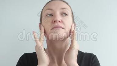 一个漂亮的女人在她的皮肤上涂上抗皱保湿油。