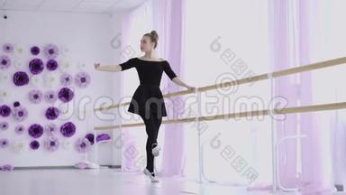 年轻漂亮的芭蕾舞演员穿着白色的芭蕾舞裙，在她的尖角芭蕾舞鞋上优雅地跳舞。
