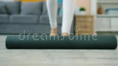低镜头瑜伽学生滚出<strong>垫子</strong>然后赤脚在家做运动